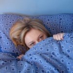 Girl in bed under duvet